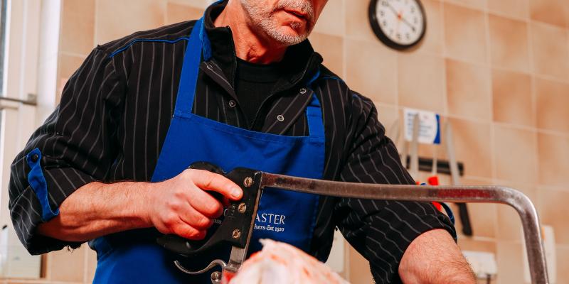 F Doncasters Butchers worker carving meat